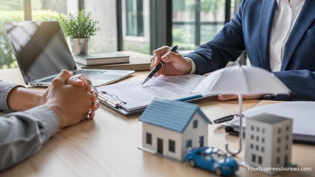 insurance agent reviewing policy with client at desk