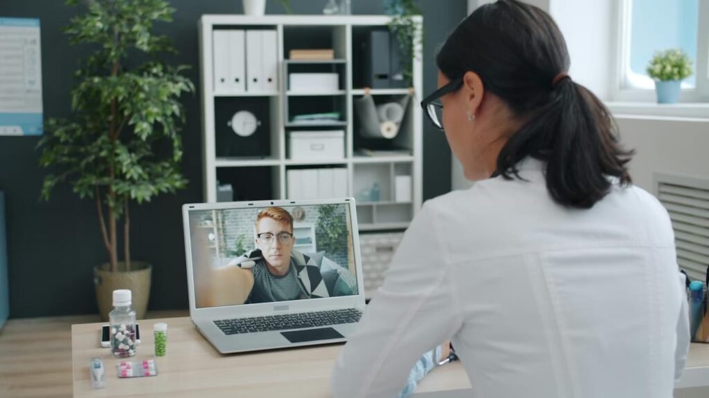 Virtual Healthcare Payment Solutions: Modern Payer-to-Provider Workflows Doctor conducting an online telehealth consultation with a patient via video call.