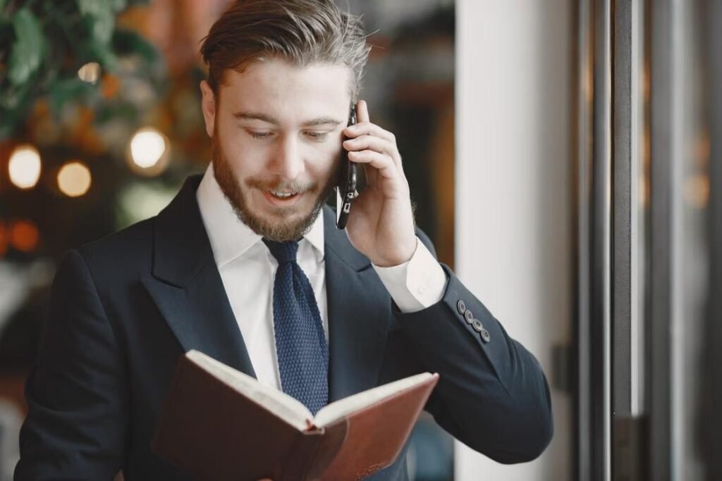Cross-Functional Team Management: Align Departments, Reduce Silos, and Improve Operational Outcomes Business leader coordinating teams while reviewing notes and speaking on the phone.