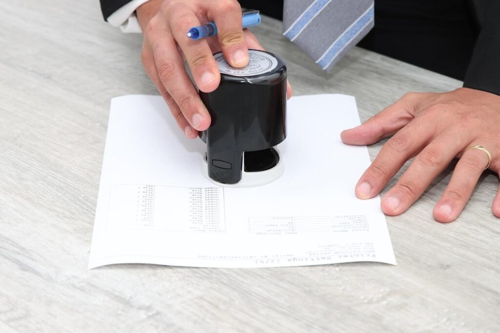 4 Signature Stamp Providers Compared, Plus How to Use One Person using a signature stamp on a business document